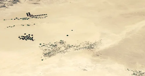 High-altitude circular tracking shot of desert farms in Libya Stock Footage 97455355