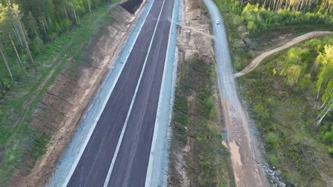 A high-altitude descent over a newly paved road s Stock Footage 344662525