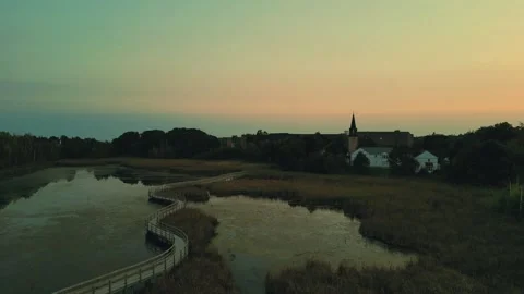 High Altitude Drone Flight Over A Marsh With Curvy Boardwalk And Church Video stock 255310793
