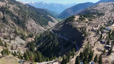 High Altitude Drone Flyover of Alpine Slopes, Dirt Roads and Mountain Ch Stock Footage 339381250