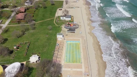 High Altitude Drone Perspective Across Coastal Park And Resort Buildings Area Vidéo 332938445