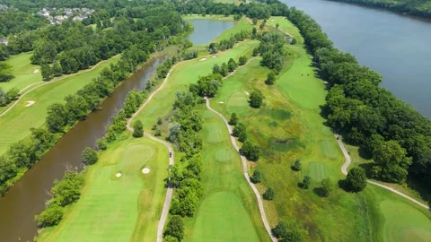 High-altitude Drone Shot Over Lush Riverfront Golf Course on Sunny Day Stock Footage 346185890
