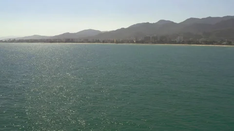 High altitude drone shot tracking over sea towards seaside town. Stock-Footage 150406449