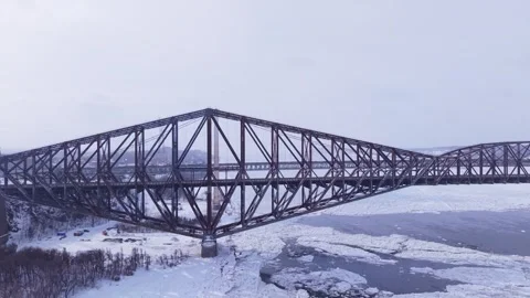 High altitude drone shot of winter bridge traffic above drifting ice Stock Footage 328439851