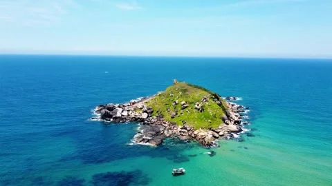 High altitude drone view of a rocky islet with boat nearby 4K Stock Footage 340068590