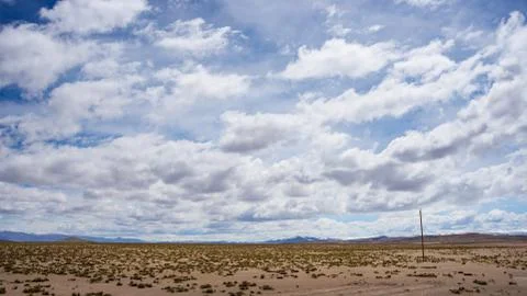 High altitude flowing stream in harsh barren landscape with scenic dramatic s Stock Photos