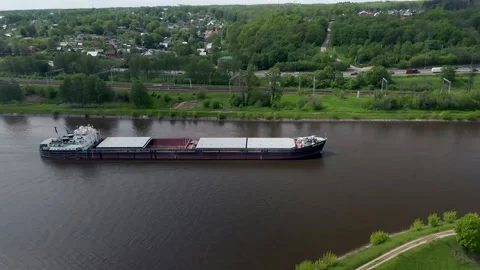High altitude flying over a cargo commercial ship sailing down the river Stock Footage 132086748
