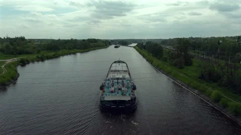 High altitude flying over a cargo commercial ship sailing down the river Stock Footage 132087030