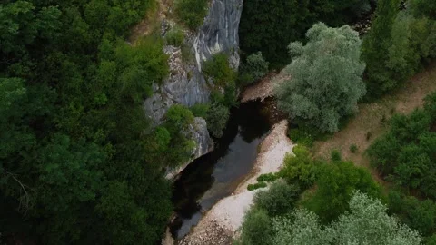 High Altitude Forward Motion Above River Revealing Towering Rock Face and Fo Stock Footage 320050411