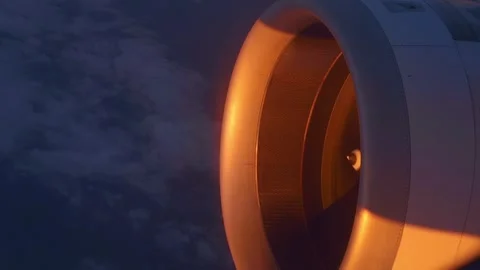 At high altitude, a jet engine of an airplane, illuminated by the setting sun  Stock Footage 323836923