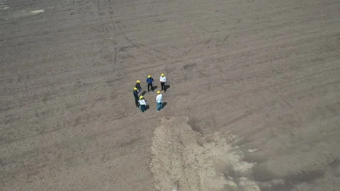 High altitude long shot of a team of building inspectors gathered on a vast Stock Footage 337191291