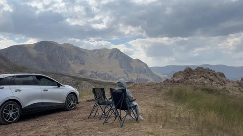 High Altitude Mountain View with Person Relaxing Near Rocky Landscape Stock Footage 343830425