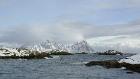 High altitude mountains with cloudy sky background and ocean waves splashing Stock Footage 121574447