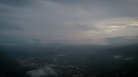 High-Altitude Perspective Above Mist-Shrouded Township Glowing at Nightfall Video stock 316797866