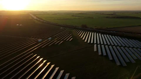 High altitude perspective of solar panel rows at dusk with golden sunlight Stock Footage 330842333