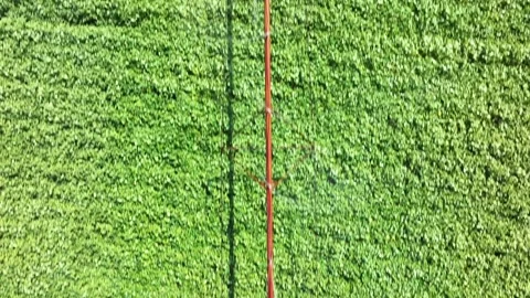 High altitude tracking shot of an irrigation pivot irrigating a lush green .. Stock Footage 294746554