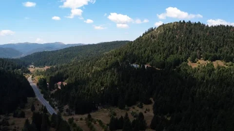 High altitude valley road through alpine forest with traditional red roof house Stock Footage 326354403