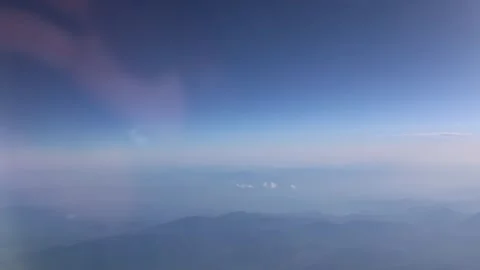 High altitude view with deep blue sky fading into soft pastel haze over distant  Stock Footage 310856631
