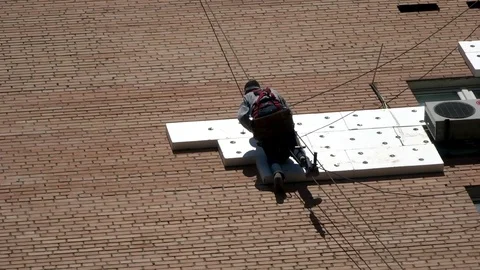 High-altitude work: nailing insulating material to the wall of the building Stock Footage 91320315