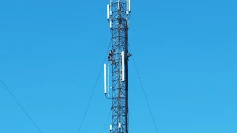 High-altitude work. Two workers man service a cell tower, install new equipment Video stock 309103334