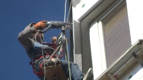 High-altitude worker with a drill insulates the balcony Stock Footage 93302628