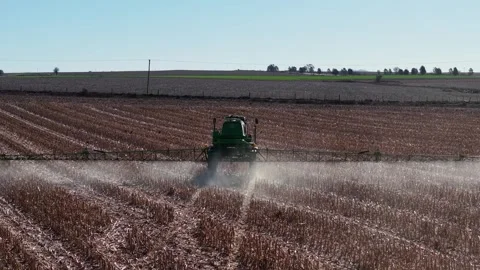 High angle 4K drone footage of farm machinery applying herbicides and ferti.. Video stock 345931674