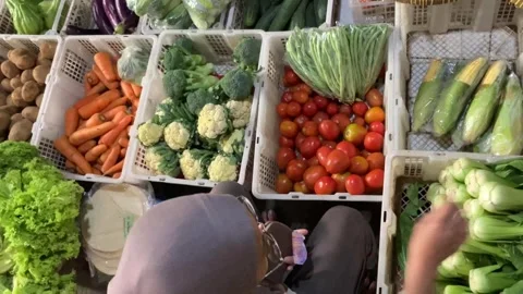 High Angle 4K of Muslim Hijab Woman Choosing Fresh Vegetables Traditional Market Stockbeeldmateriaal 337526777
