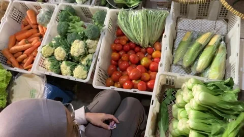 High Angle 4K of Muslim Hijab Woman Weighing Vegetables Traditional Market Stockbeeldmateriaal 337526845