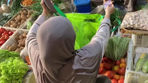 High Angle 4K of Muslim Hijab Woman Putting Vegetables in Shopping Bag Stockbeeldmateriaal 337526866
