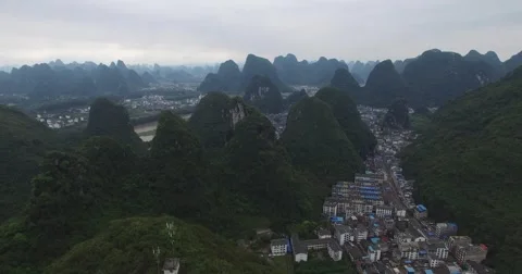 HIGH ANGLE AERIAL CRANE SHOT OF YANGSHUO CITY AND MOUNTAINS IN CHINA Stock Footage 61781274