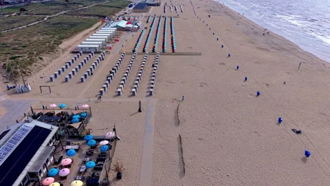 High-angle aerial drone clip of organized beach cabins, colorful umbrellas Vídeo Stock 347029149