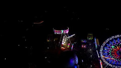 High-angle aerial drone shot of a vibrant night fair with glowing carnival 스톡 동영상 325187457