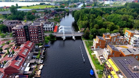 High angle aerial drone video clip of white drawbridge spanning urban river Stock Footage 342416681