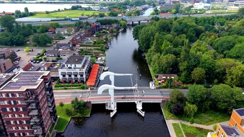 High angle aerial drone video clip of white drawbridge spanning urban river Stock Footage 342443444