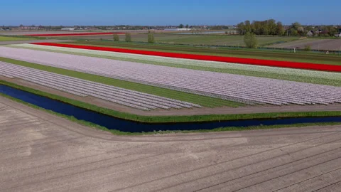 A high-angle aerial drone view looking over large, open fields featuring Stock Footage 336279101