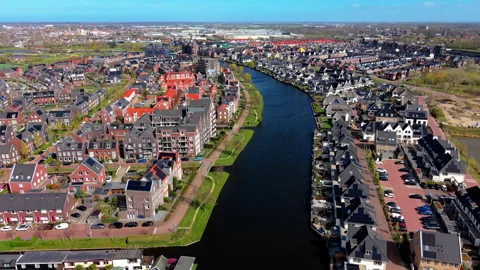 High-angle aerial drone view of a wide canal curving through a modern Dutch. Stock Footage 337706651