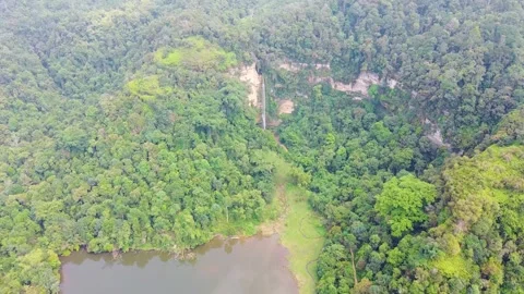 High angle aerial drone view of a tall waterfall in dense green Harau Valley. Stock Footage 346276842