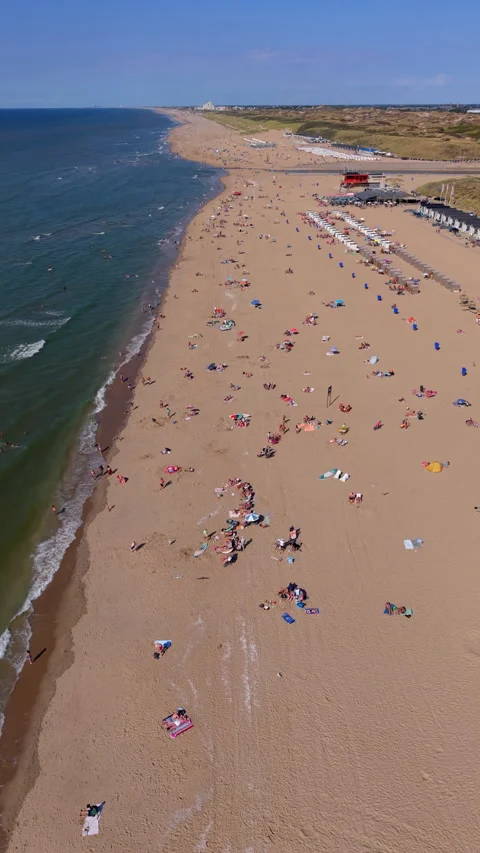 High-angle aerial drone view over crowded sandy beach, shoreline waves 動画素材 347126330