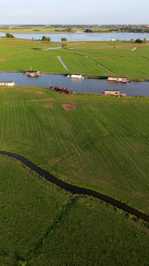 High-angle aerial drone view of green polder fields, drainage canals, house Stock-Footage 347147235
