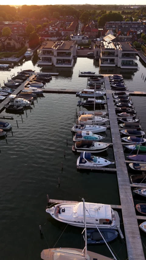 High-angle aerial drone view of boats and yachts moored along wooden piers Vídeo Stock 347160265