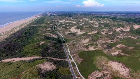 High-angle aerial drone view of coastal sand dunes, winding bicycle road 動画素材 347328771