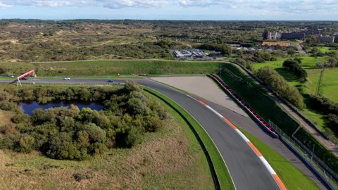 High-angle aerial drone view of Circuit Zandvoort race track wide sweeping Stock Footage 347527995