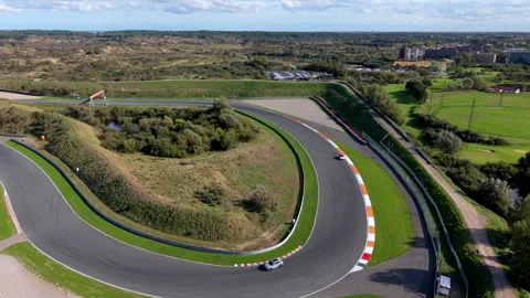 High-angle aerial drone view of Circuit Zandvoort race track curved turn 動画素材 347531410