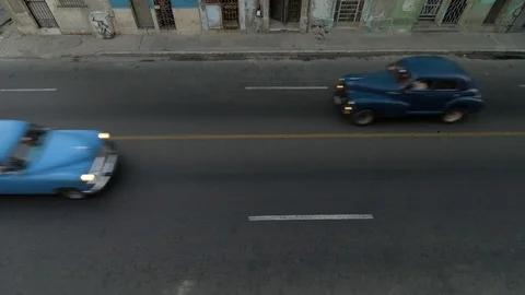 A high angle aerial establishing shot of classic american cars passing on street Stock Footage 99747008