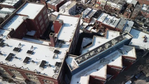 High angle aerial perspective flying backwards away from a brick school Stock Footage 331085396