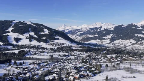 A high-angle aerial shot captures the picturesque winter landscape of Megeve, a Stock Footage 346689358