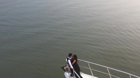 High-angle aerial shot focusing on a couple standing at the very tip of the Vídeo Stock 324690618