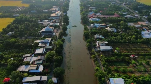 High angle aerial shot of a misty countryside canal and rice fields at sunris Stock Footage 337532512