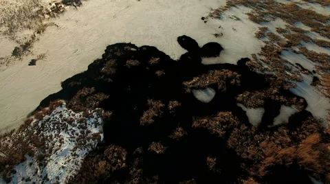 High angle aerial shot of open water and reeds by a melting lake in springtime Stock Footage 62642742