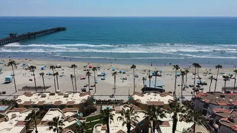 High-Angle Aerial View of Beachfront Resorts and Ocean Pier 動画素材 336794174